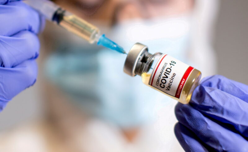 M File Photo: A Woman Holds A Medical Syringe And A Small Bottle Labelled "coronavirus Covid 19 Vaccine