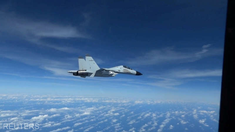File photo: chinese navy j 11 fighter jet flies close to a u.s. air force rc 135 aircraft over the south china sea